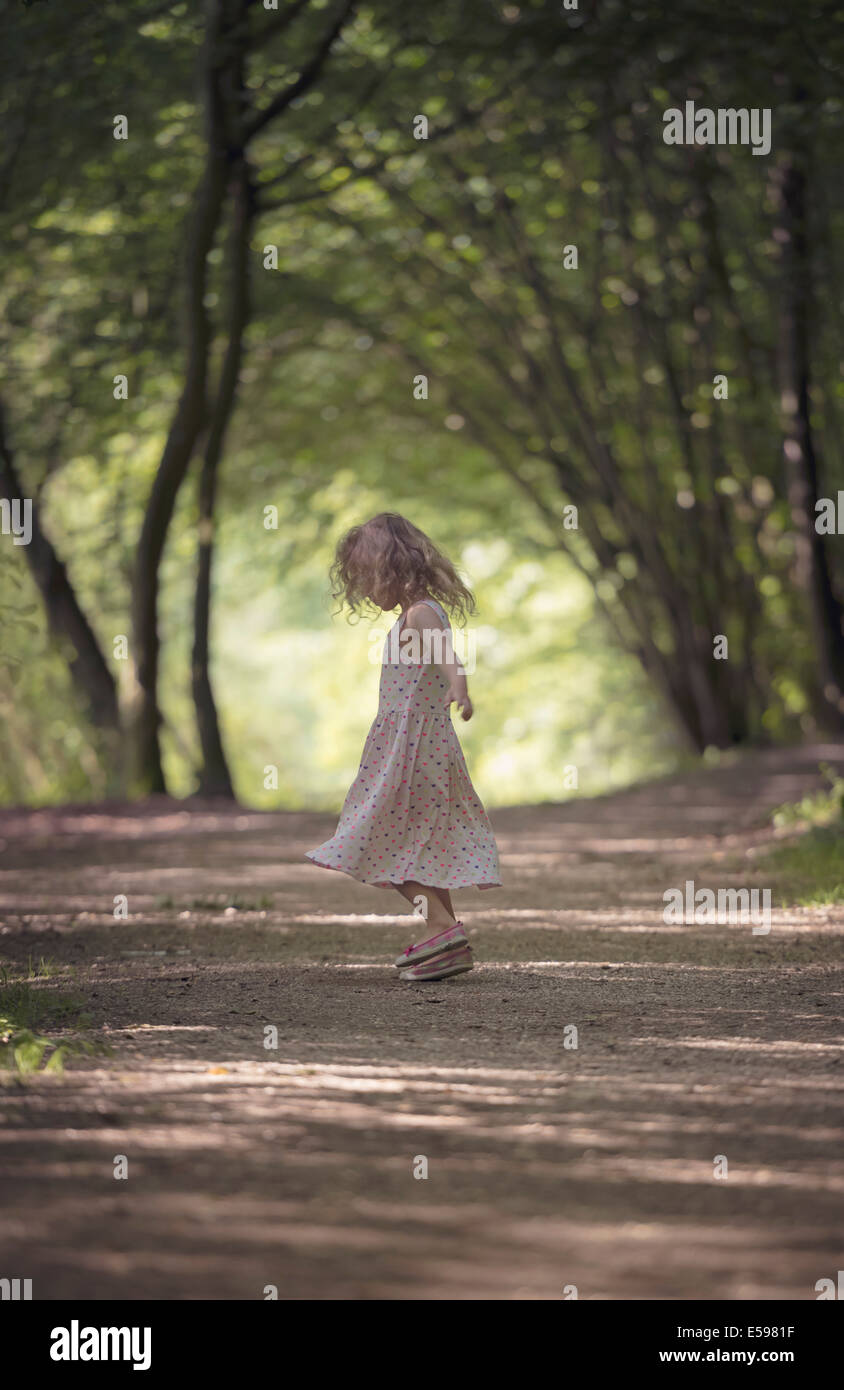 Kleines Mädchen tanzen auf Waldweg Stockfoto