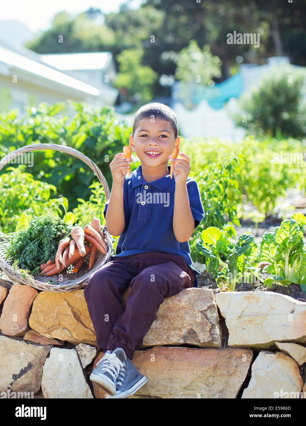 Junge mit Korb von Produkten im Garten Stockfoto