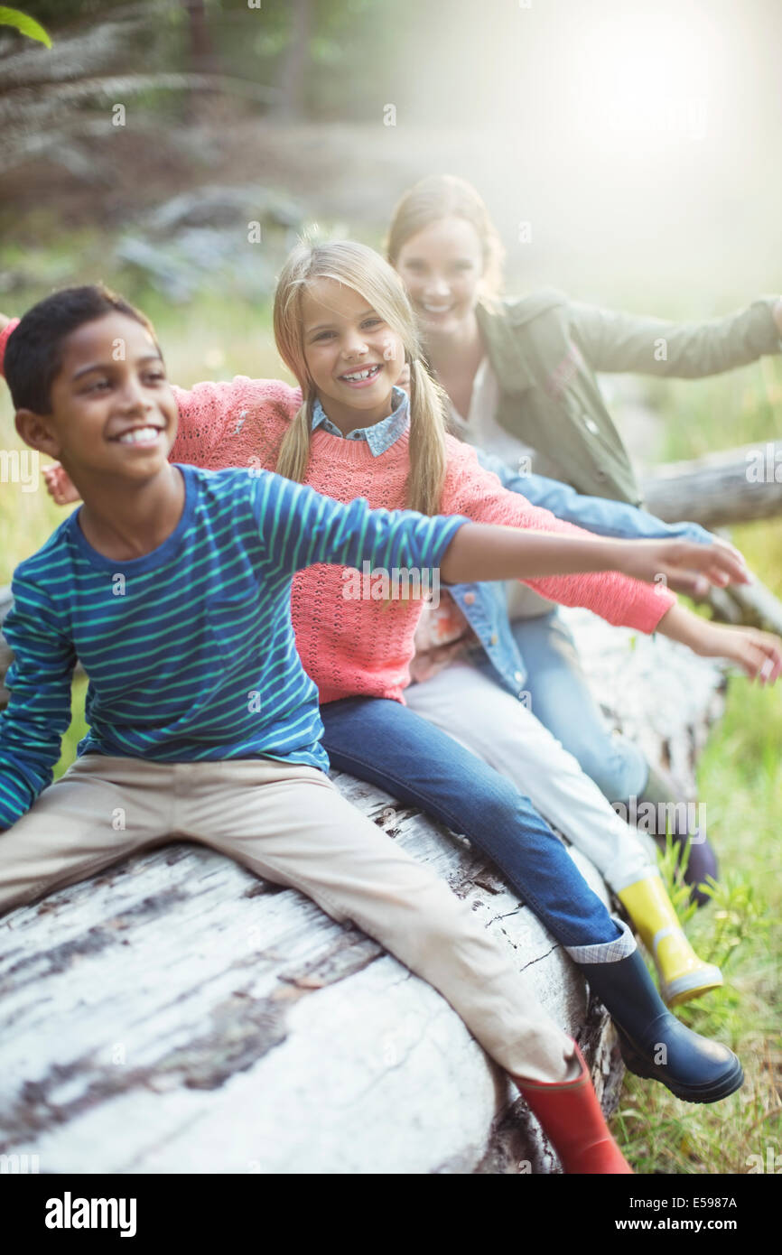 Schüler und Lehrer sitzen auf melden Sie sich im Wald Stockfoto