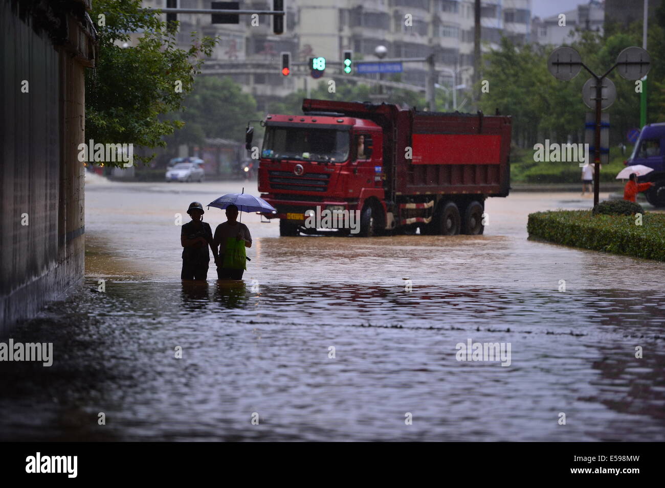 Der chinesischen Nanchang, Jiangxi Provinz. 24. Juli 2014. Fußgänger gehen in einer überfluteten Straße in der Grafschaft De'an, Osten Chinas Jiangxi Provinz, 24. Juli 2014. Eine Person hatte tot während zwei andere fehlende als Taifun Matmo Hit der Grafschaft bestätigt worden. Mehr als 100.000 Anwohner wurden durch den Taifun betroffen. Bildnachweis: Zhou Mi/Xinhua/Alamy Live-Nachrichten Stockfoto