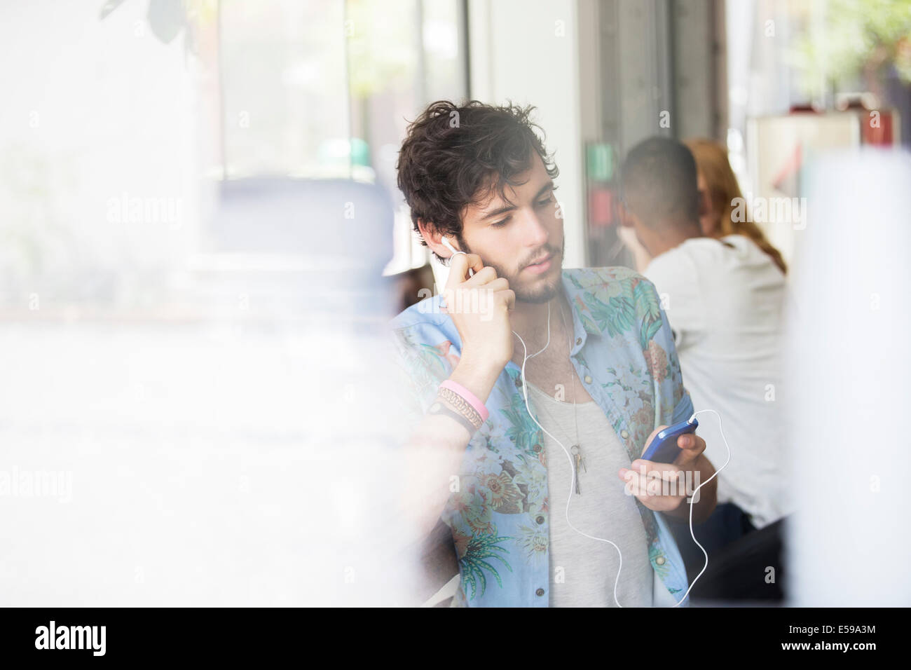 Mann, anhören von MP3-Player im café Stockfoto