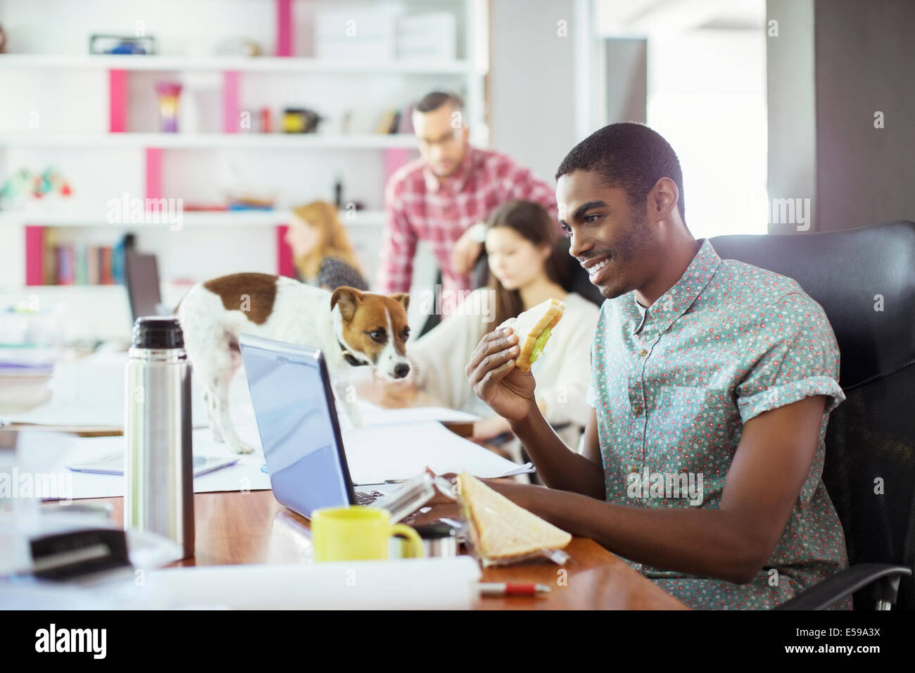 Mann isst am Konferenztisch im Büro Stockfoto