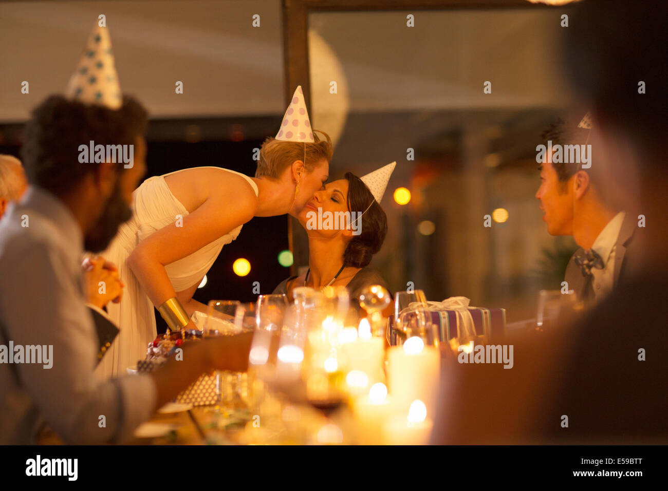 Frau küssen Freundes Wange auf Geburtstagsparty Stockfoto