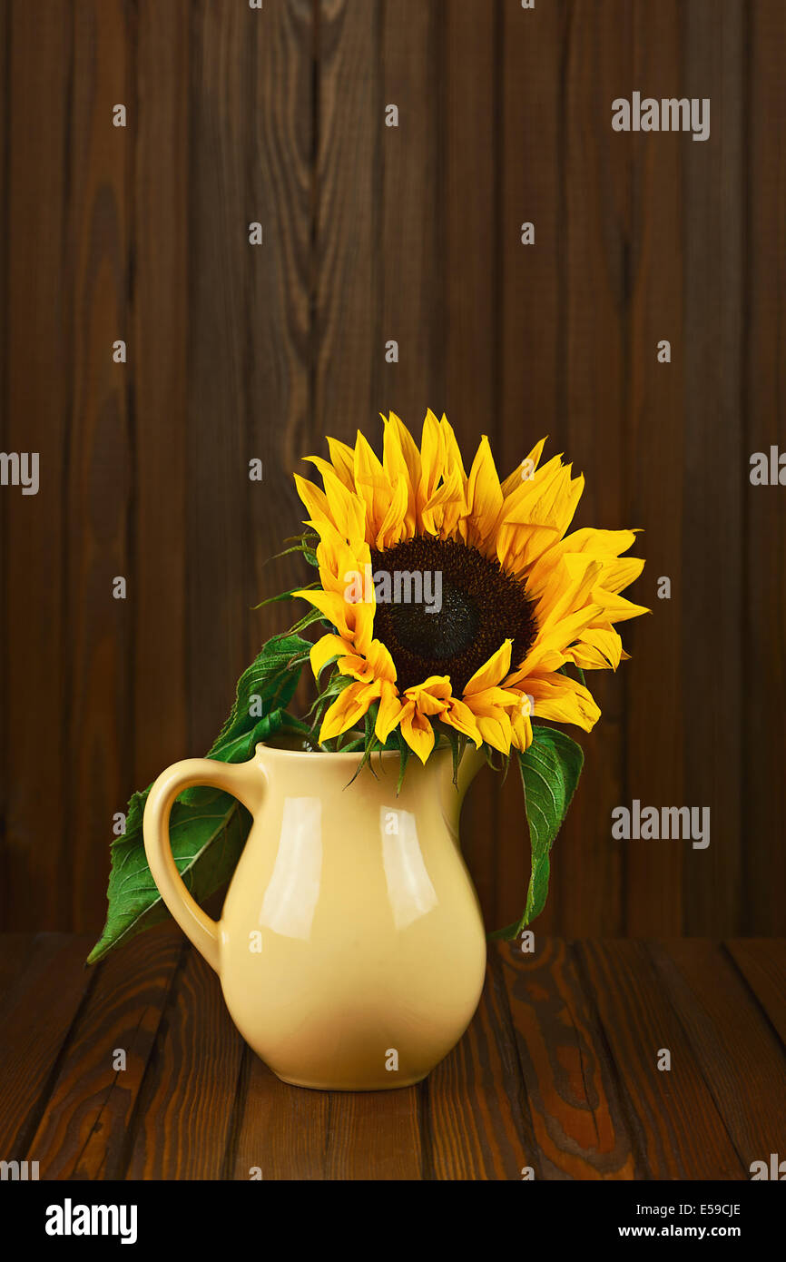 Stilleben mit Sonnenblumen in Vase auf hölzernen Hintergrund. Closeup. Stockfoto