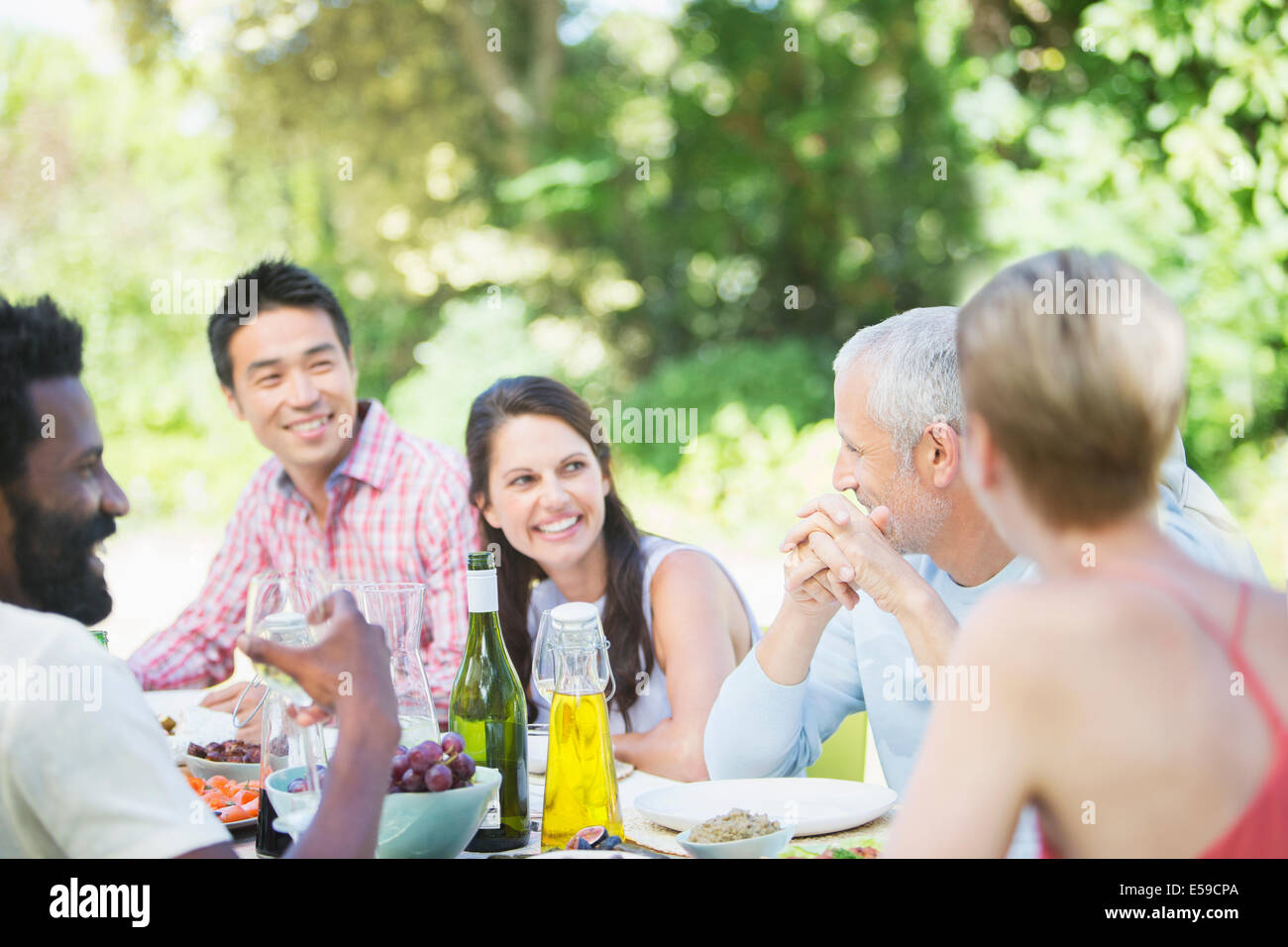 Freunde im Gespräch am Tisch im freien Stockfoto