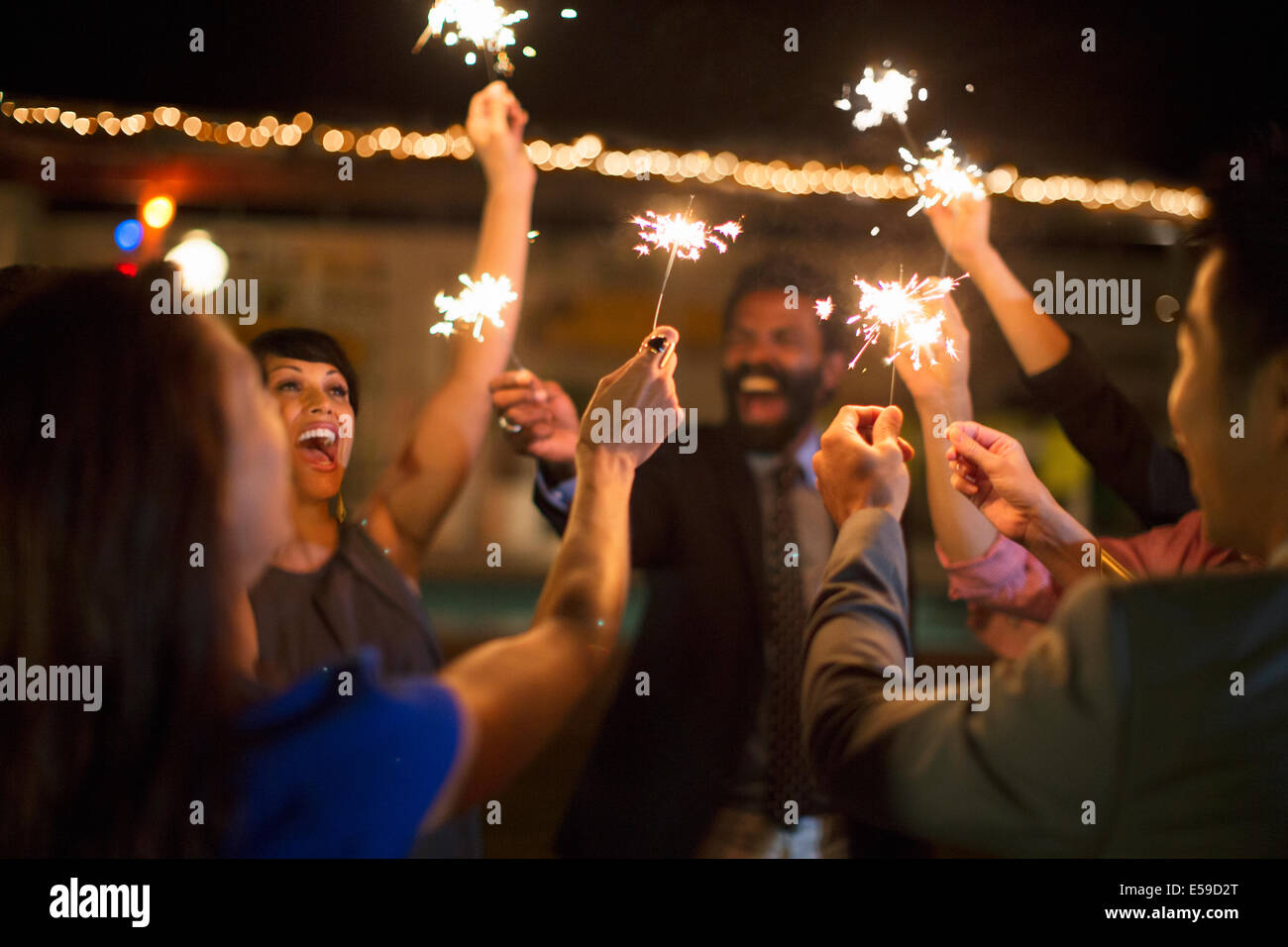 Freunde mit Wunderkerzen auf Party Spielen Stockfoto