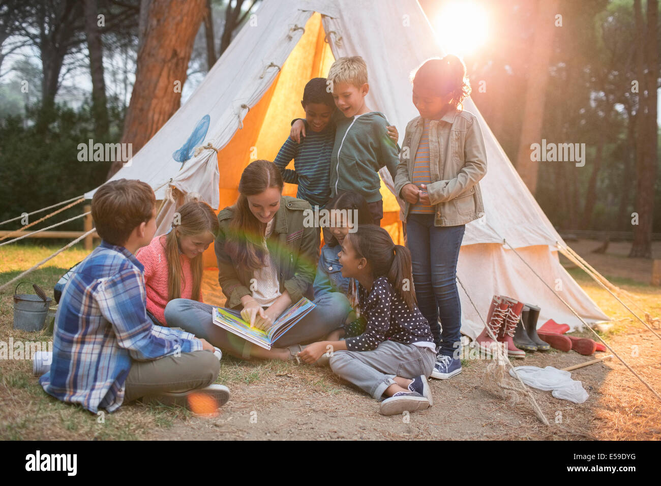 Lehrer und Schüler lesen auf Campingplatz Stockfoto
