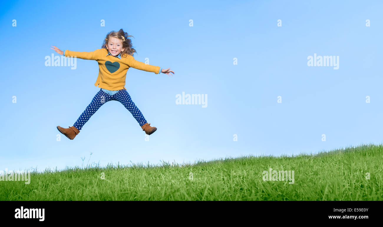Mädchen springen vor Freude auf grasbewachsenen Hügel Stockfotografie - Alamy