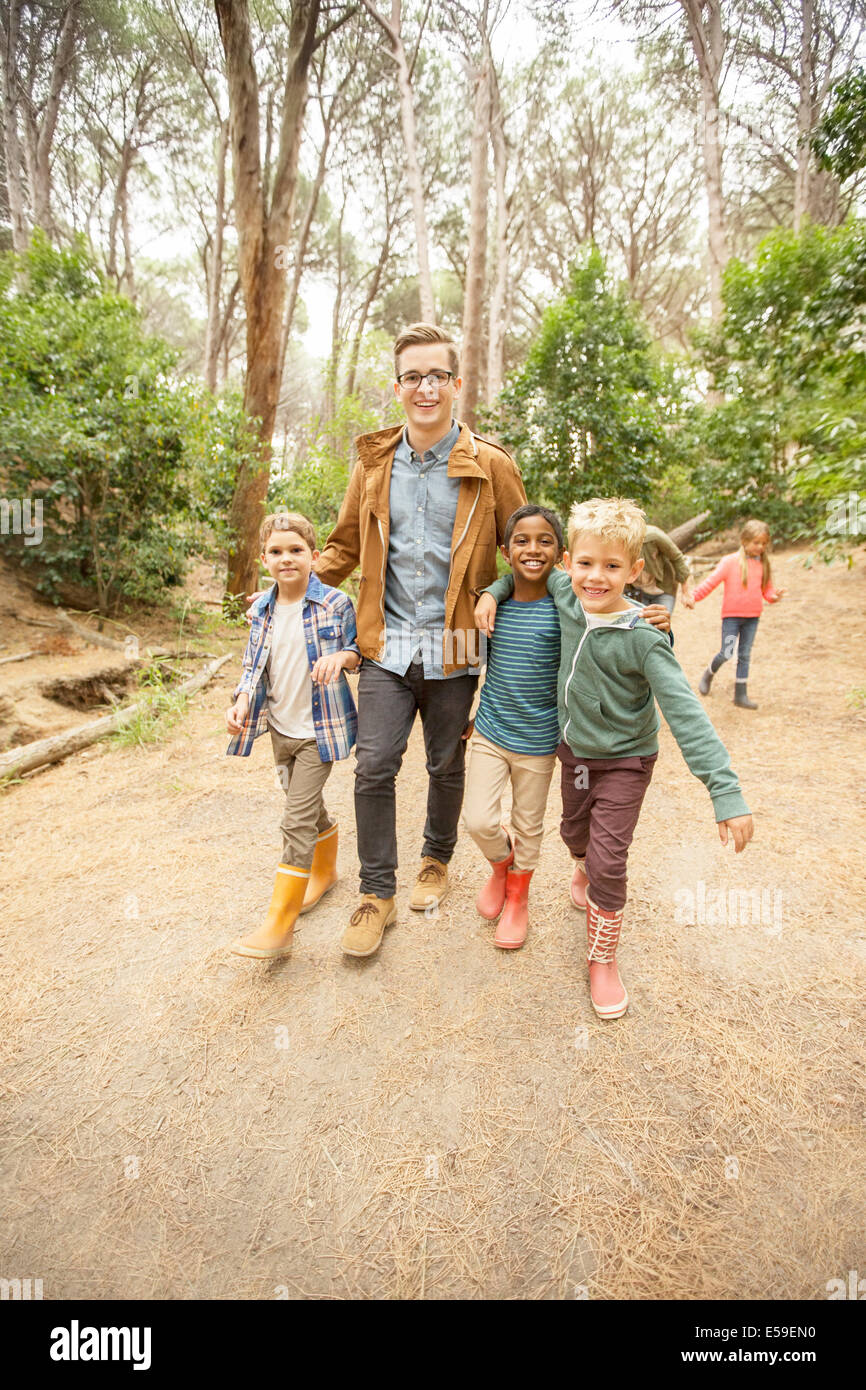 Schüler und Lehrer, die zu Fuß in Wald Stockfoto