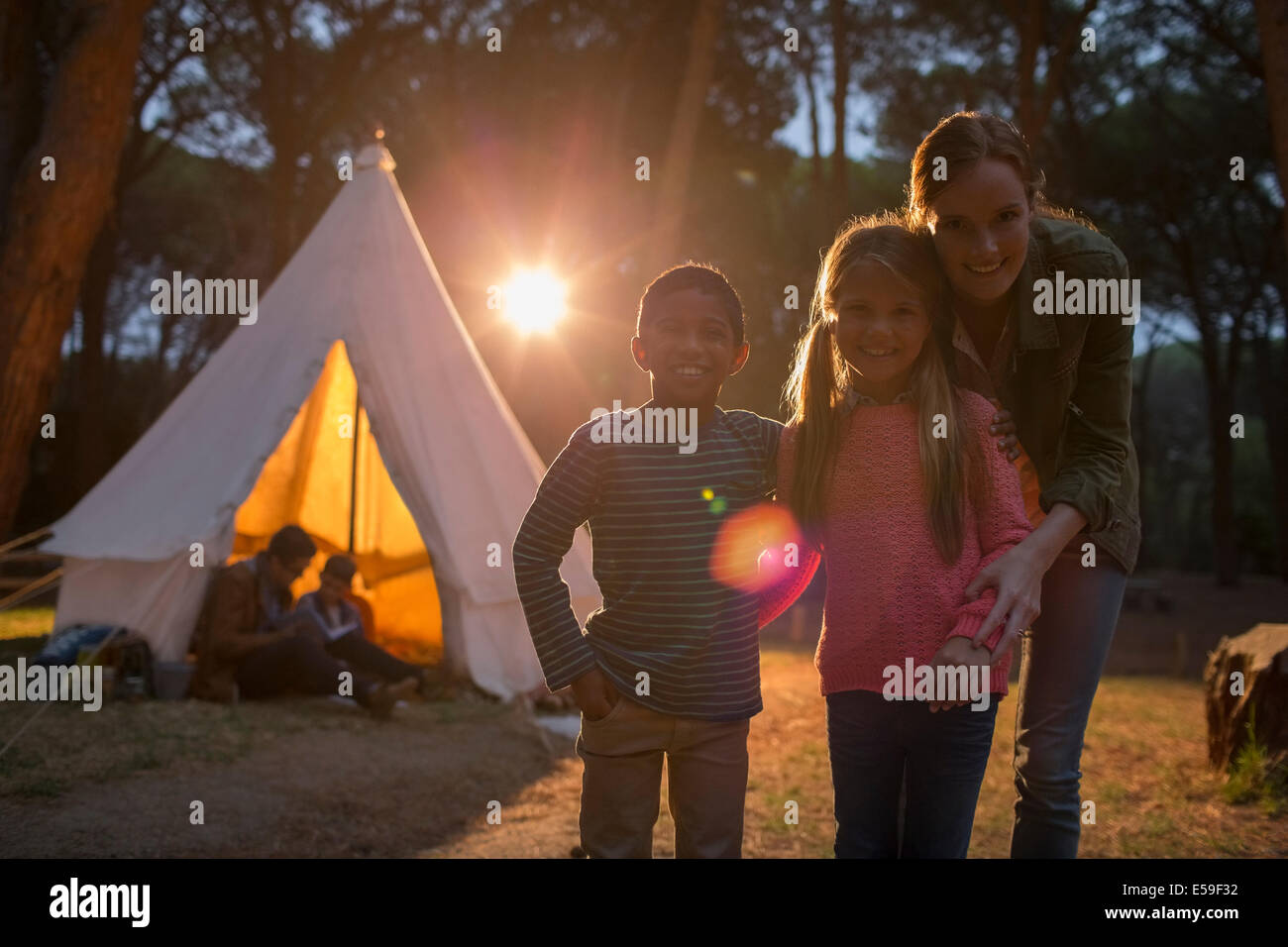 Schüler und Lehrer lächelnd auf Campingplatz Stockfoto