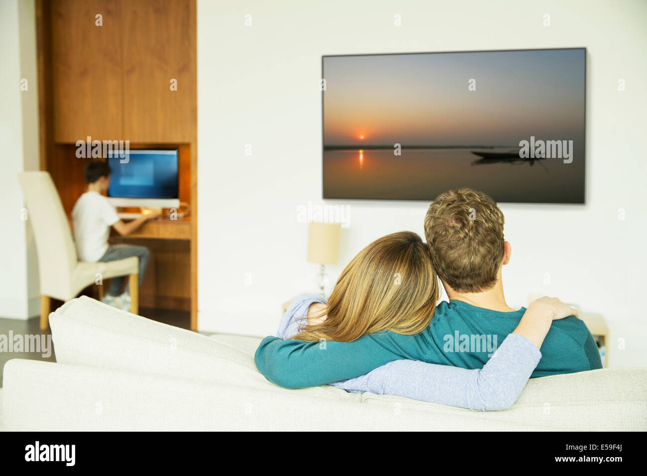 Paar vor dem Fernseher im Wohnzimmer Stockfoto