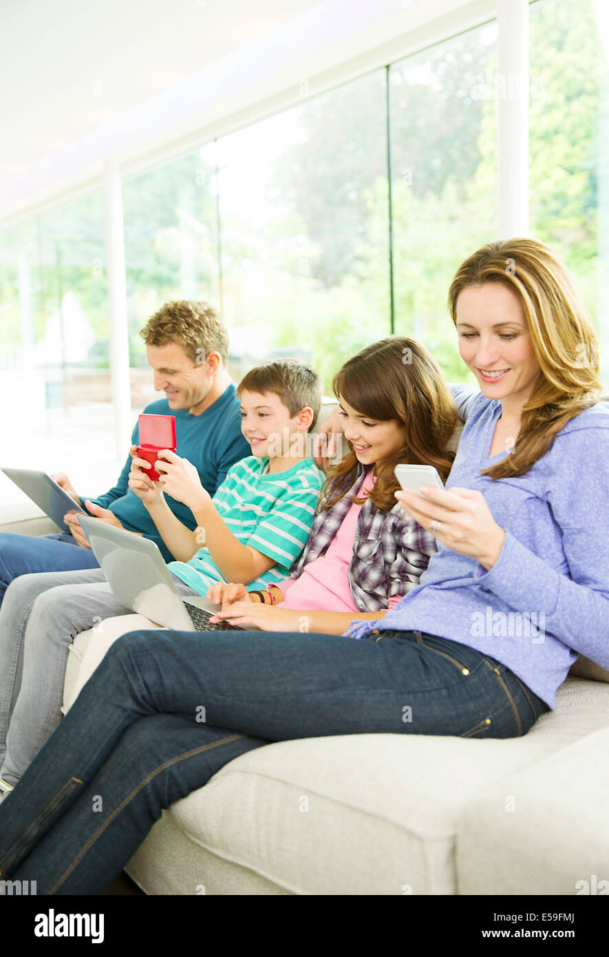 Familie mit Hilfe von Technologie auf sofa Stockfoto