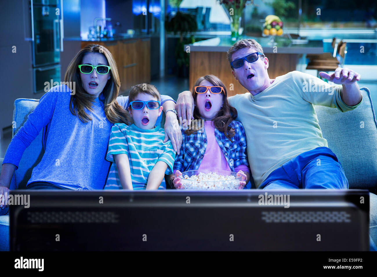 Familie vor dem 3D Fernseher im Wohnzimmer Stockfoto