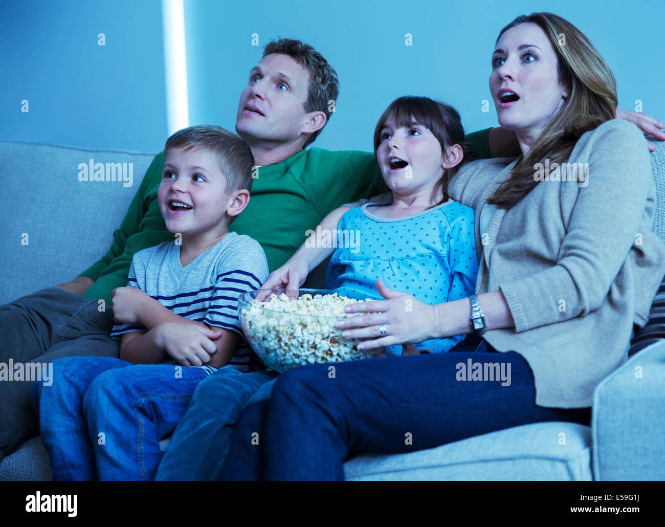 Familie vor dem Fernseher im Wohnzimmer Stockfoto