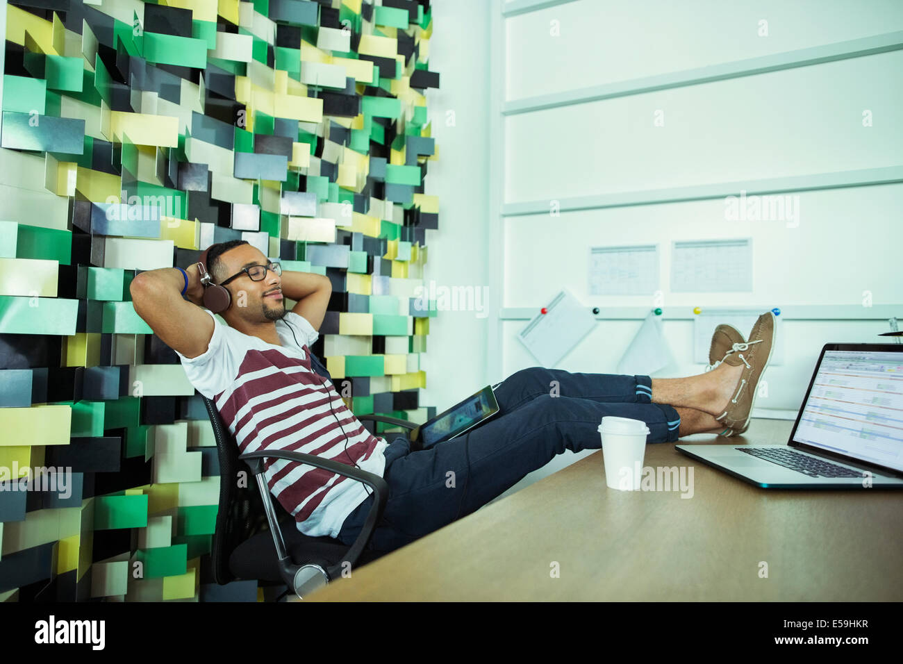 Mann am Schreibtisch im Büro entspannend Stockfoto