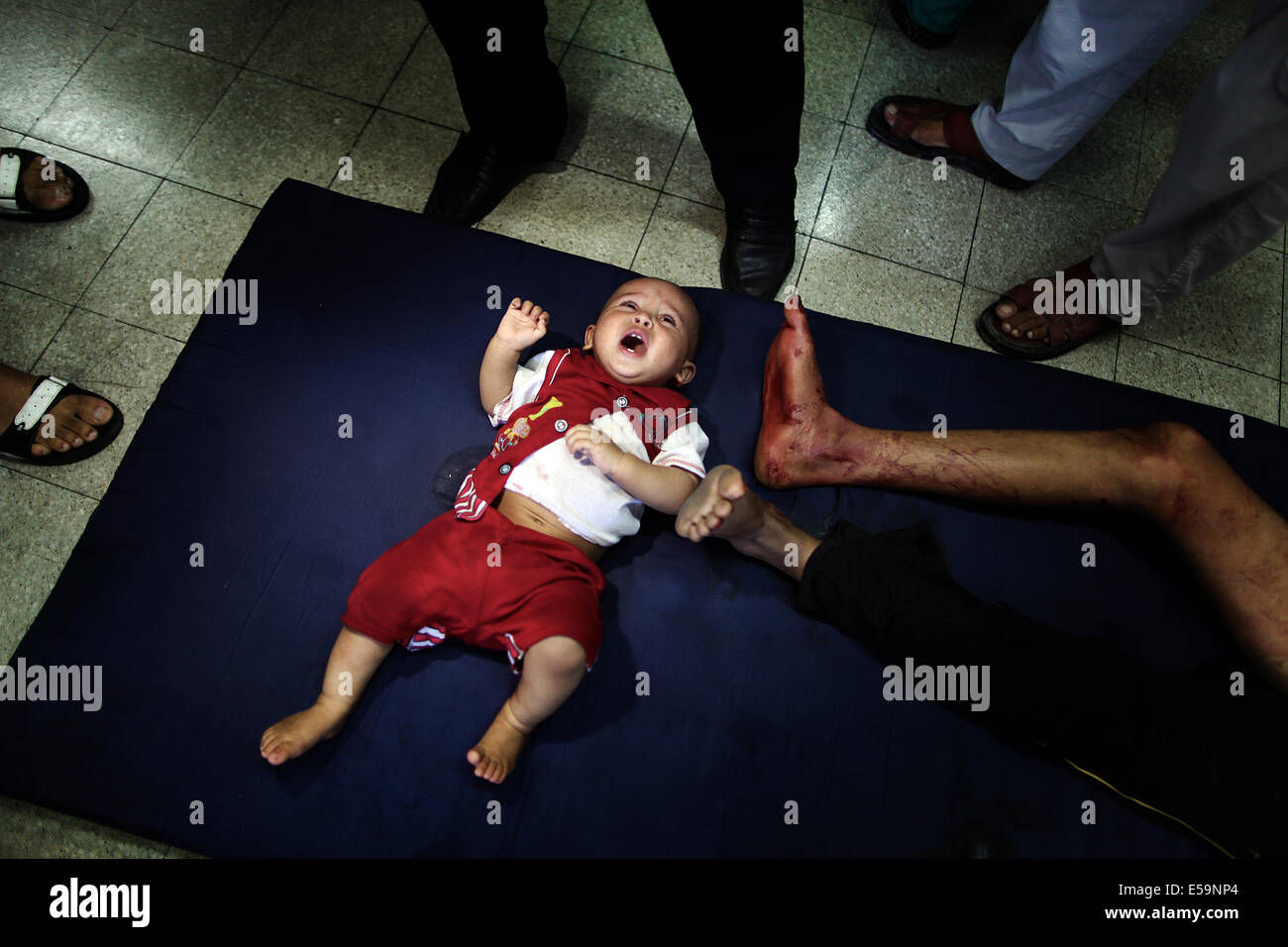 Gaza-Stadt, Gazastreifen, Palästinensische Gebiete. 24. Juli 2014. Palästinensische Kinder, verwundet in einem israelischen Angriff auf eine Verbindung eine UN-Schule in Beit Hanoun im nördlichen Gazastreifen Gehäuse lag auf dem Boden von einer Notaufnahme im Krankenhaus in Beit Lahiya Kamal Adwan. Israelische Panzergranaten schlug die Verbindung, mehr als ein Dutzend Menschen und verletzte Dutzende mehr, die Schutz vor heftige Auseinandersetzungen auf den Straßen außerhalb suchten zu töten. Bildnachweis: ZUMA Press, Inc./Alamy Live-Nachrichten Stockfoto