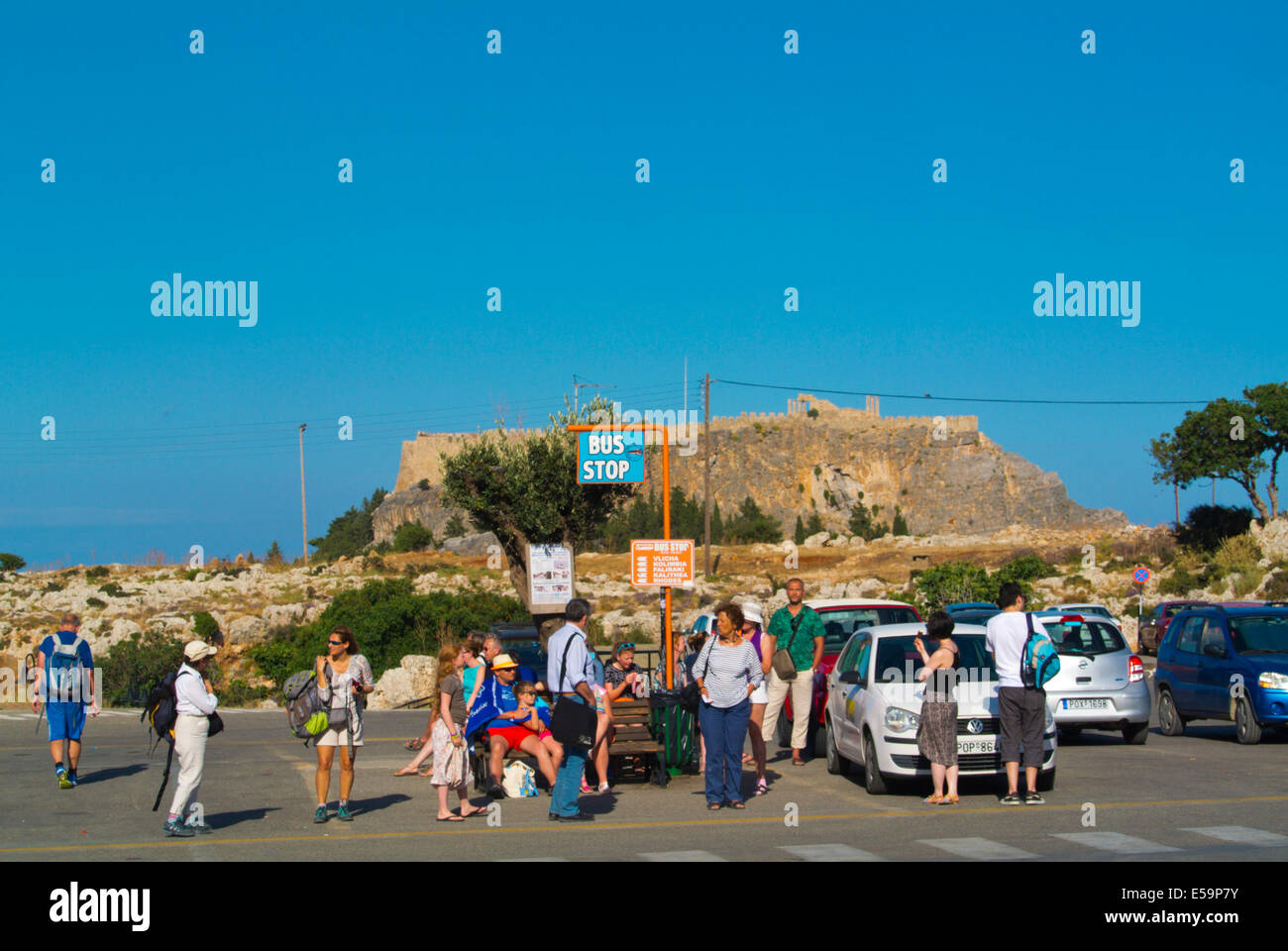 Menschen warten auf einen Bus in Richtung Rhodos-Stadt, Lindos Stadt, Insel Rhodos, Dodekanes, Griechenland, Europa Stockfoto