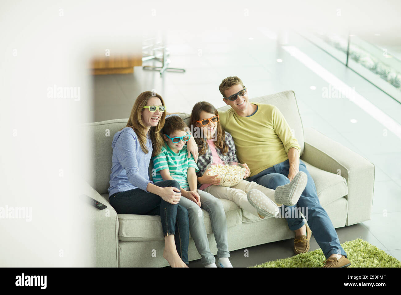 Familie vor dem 3D Fernseher im Wohnzimmer Stockfoto