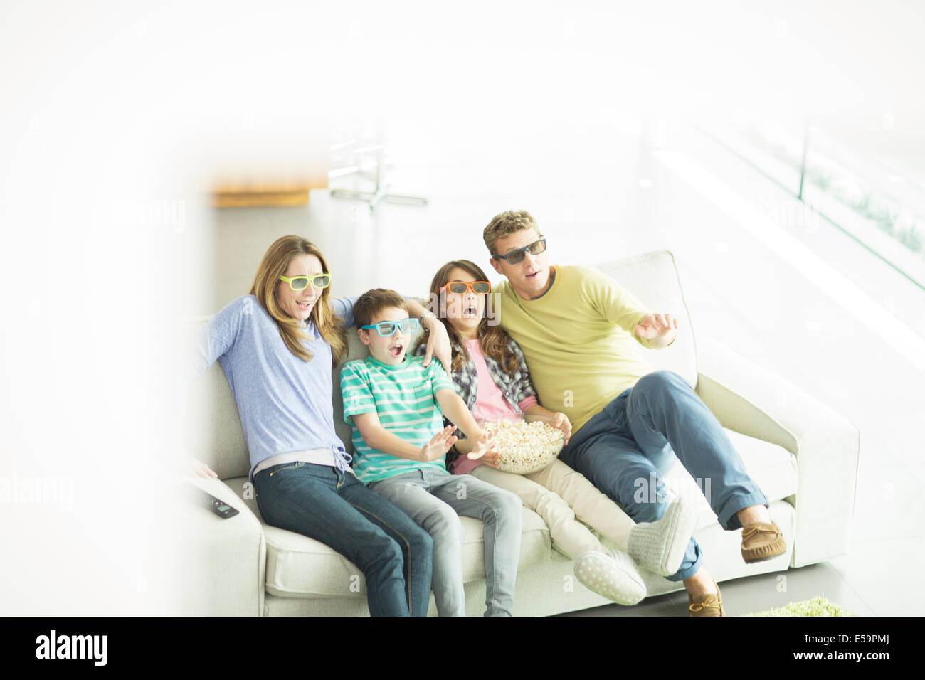 Familie vor dem 3D Fernseher im Wohnzimmer Stockfoto