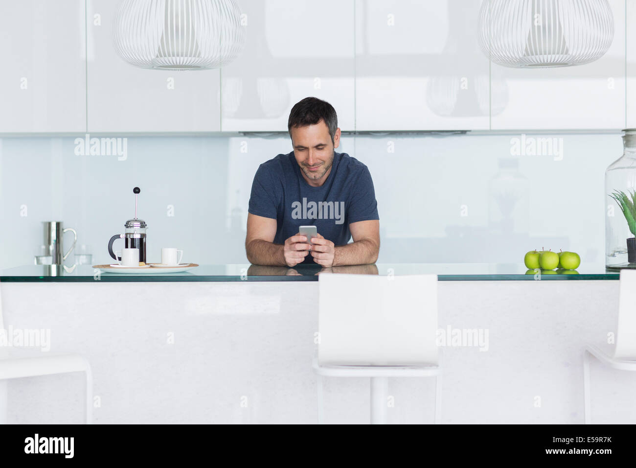 Mann mit Handy in der modernen Küche Stockfoto