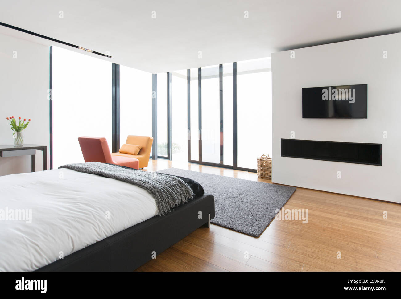 Bett und Glasschiebetüren im modernen Schlafzimmer Stockfoto