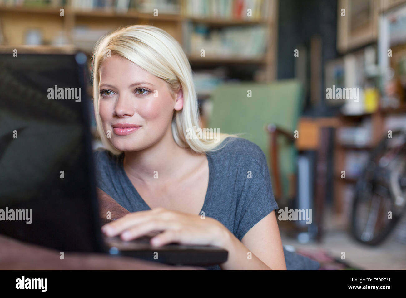 Frau mit Laptop in Studie Stockfoto