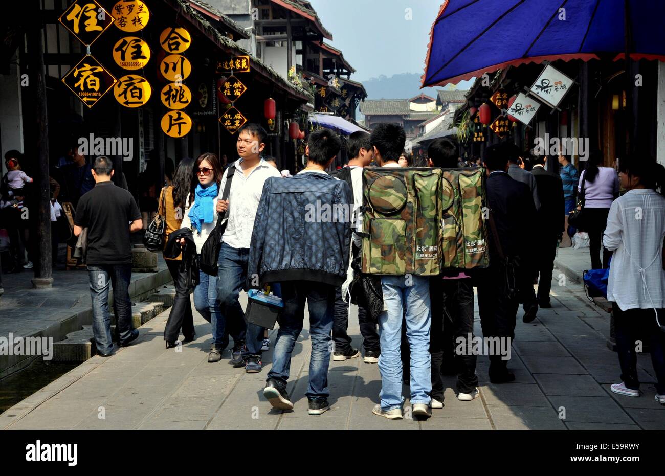 JIE ZI ANCIENT TOWN, CHINA: Eine Gruppe von Studenten mit Rucksäcken voll Jiangcheng Straße entlang Stockfoto