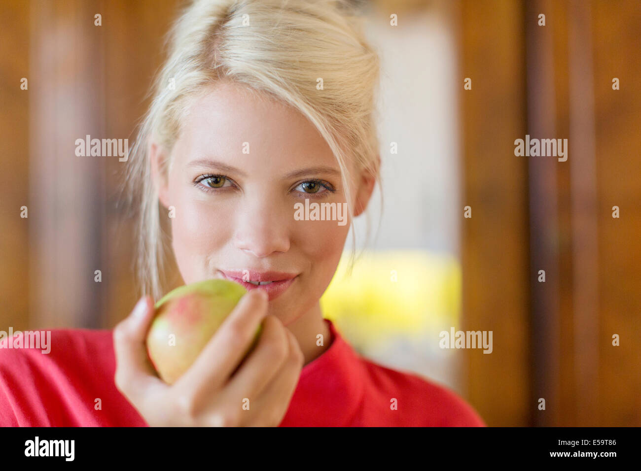 Frau zu essen Apfel im Innenbereich Stockfoto