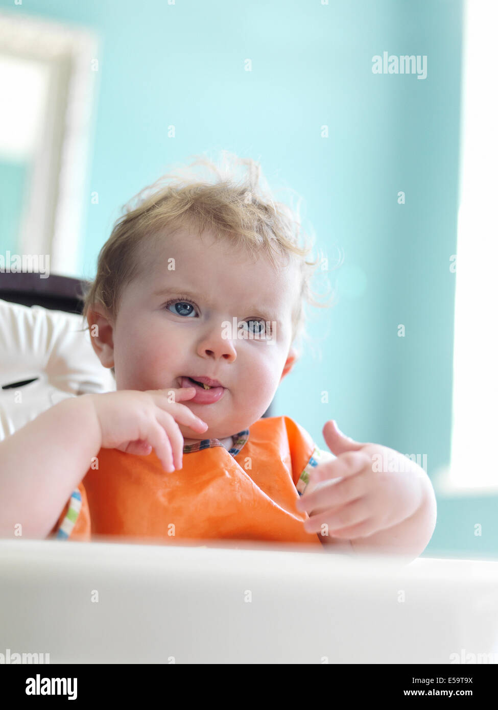 Babymädchen Essen im Hochstuhl Stockfoto