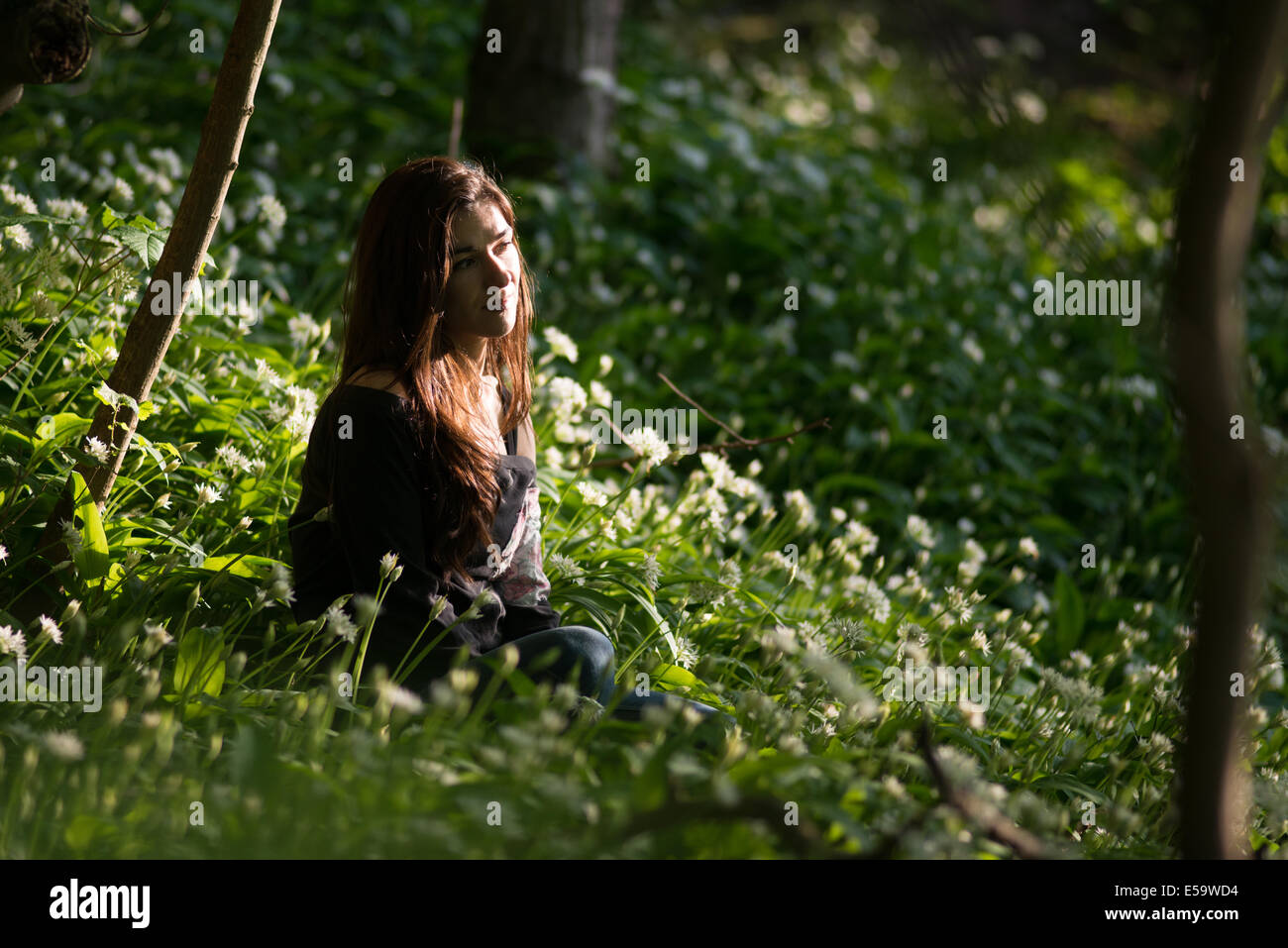 Frau sitzt im Wald. Stockfoto