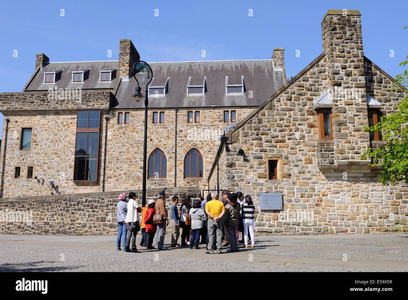 Ein Leitfaden sammelt seine Gruppe von Touristen im Museum für religiöse Kunst und Leben in Glasgow, Schottland Stockfoto