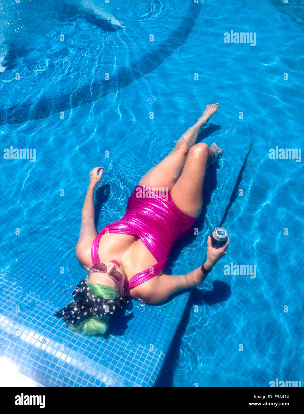 Kaukasische Frau entspannen im pool - Smartphone-aufgenommenes Stockfoto