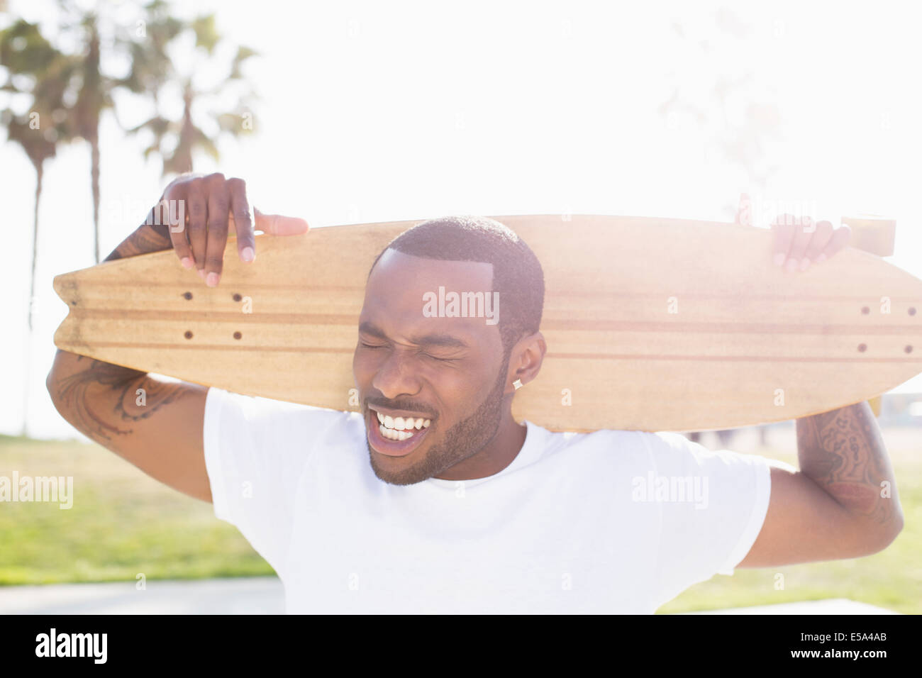 Afrikanische amerikanische Mann mit Skateboard im freien Stockfoto