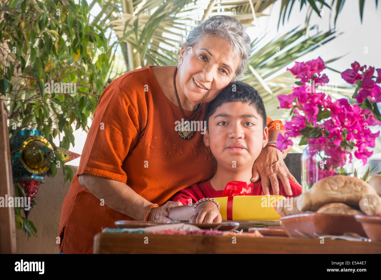 Ältere Hispanic Frau umarmt Enkel Stockfoto