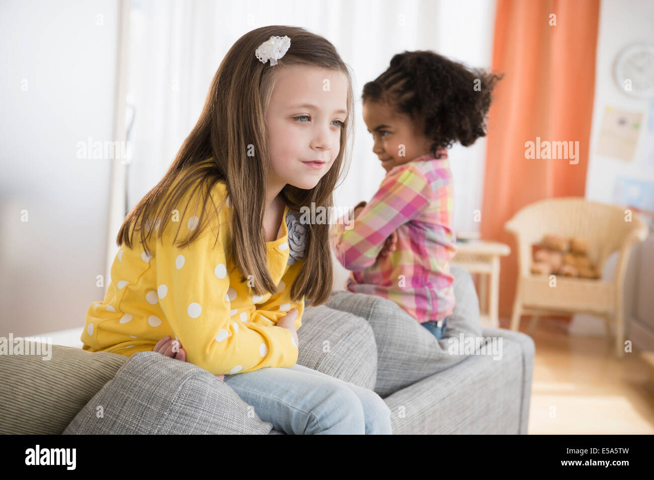 Mädchen kämpfen auf sofa Stockfoto