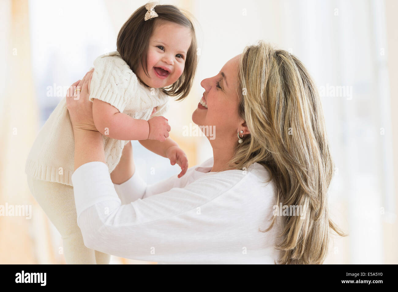 Hispanische Mutter mit Tochter im Wohnzimmer spielen Stockfoto