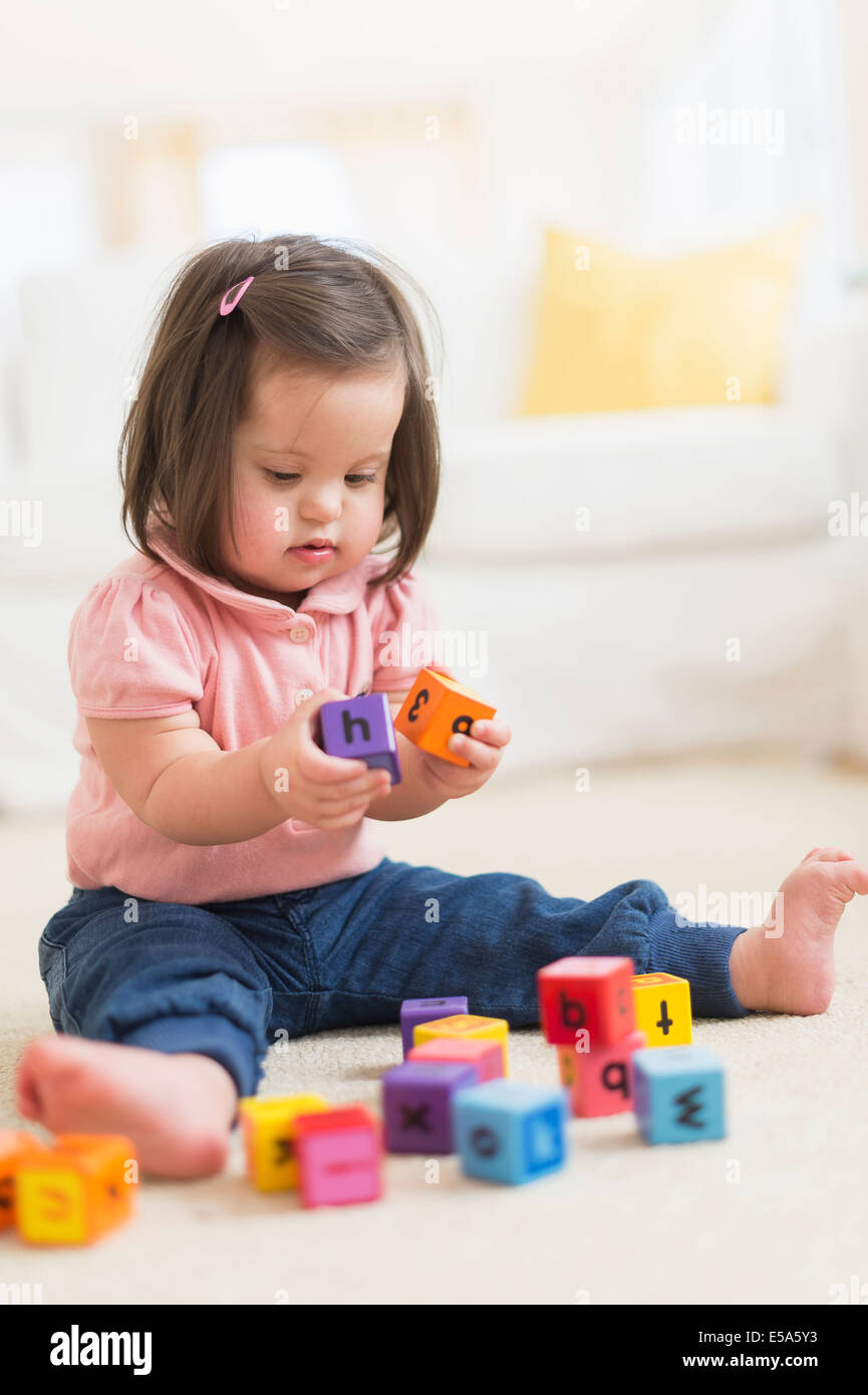 Hispanische Kind mit Down-Syndrom mit Blöcken spielen Stockfoto