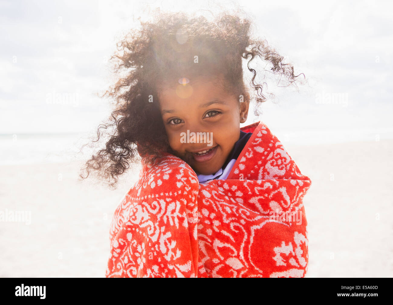 Gemischte Rassen Mädchen gewickelt Handtuch am Strand Stockfoto