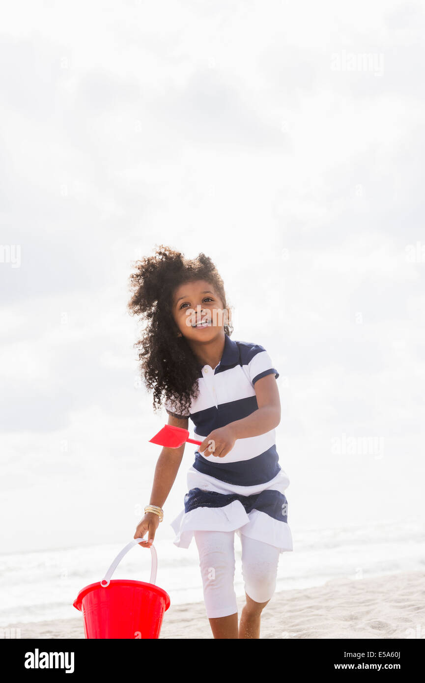 Gemischte Rassen Mädchen mit Schaufel und Eimer am Strand Stockfoto