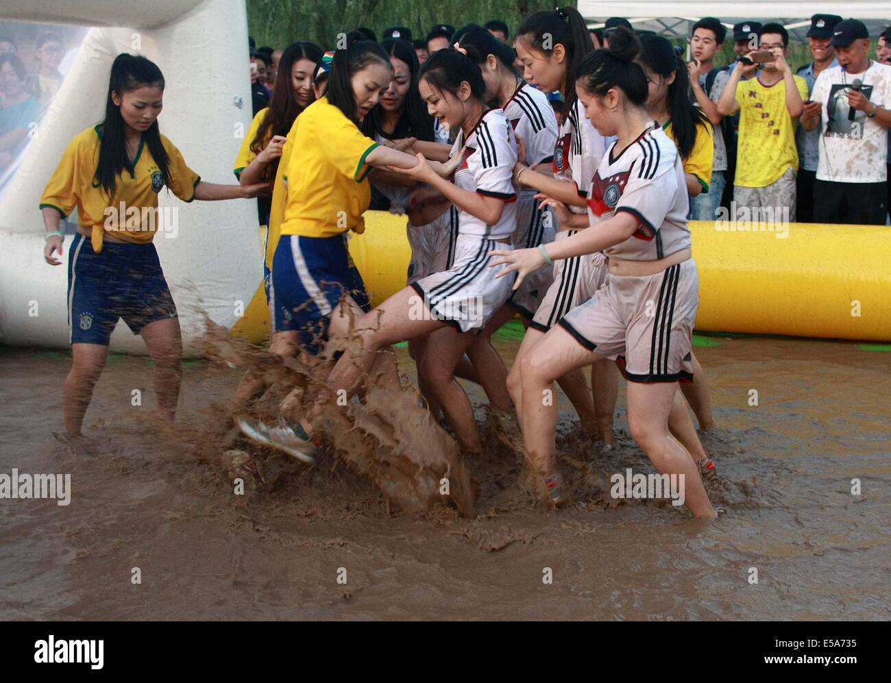 Zwei Gruppen von Mädchen in Deutschland Fußball team Trikot und Brasilien Nationalmannschaft Trikot Schlamm Fußball spielen am 13. Juli 2014 in Xi ' an, Shaanxi Provinz China.Mud Fußball aus Finnland entstanden ist, und es in China mehr und mehr populär geworden. Stockfoto