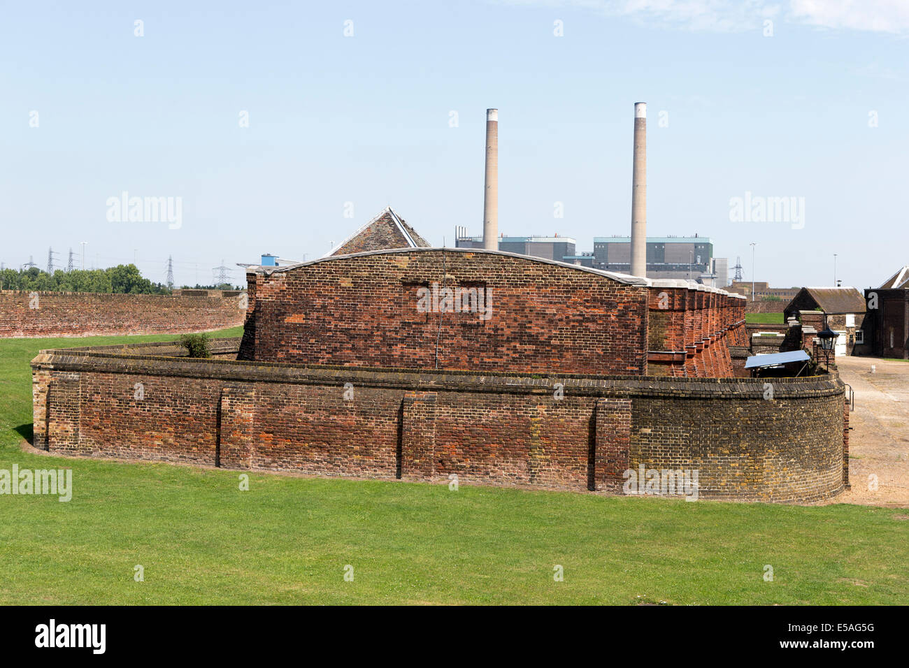 Schießpulver Magazin von Tilbury Fort mit den Schornsteinen der Tilbury Kraftwerke in den Hintergrund, Essex, England, UK. Stockfoto