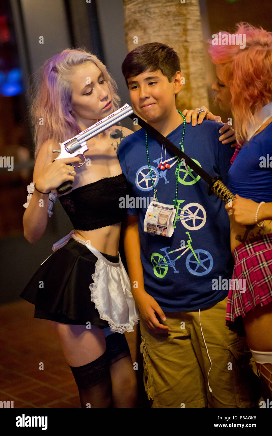 Cosplayer mit Pistole und Kunststoff Dolch bedrohlich Mann an das Gaslamp Quarter, in der Nähe der Comic-Con, ein jährlich Ausstellung über Anime, Manga, Comics, Videospielen usw. im Juli 2014. Stockfoto