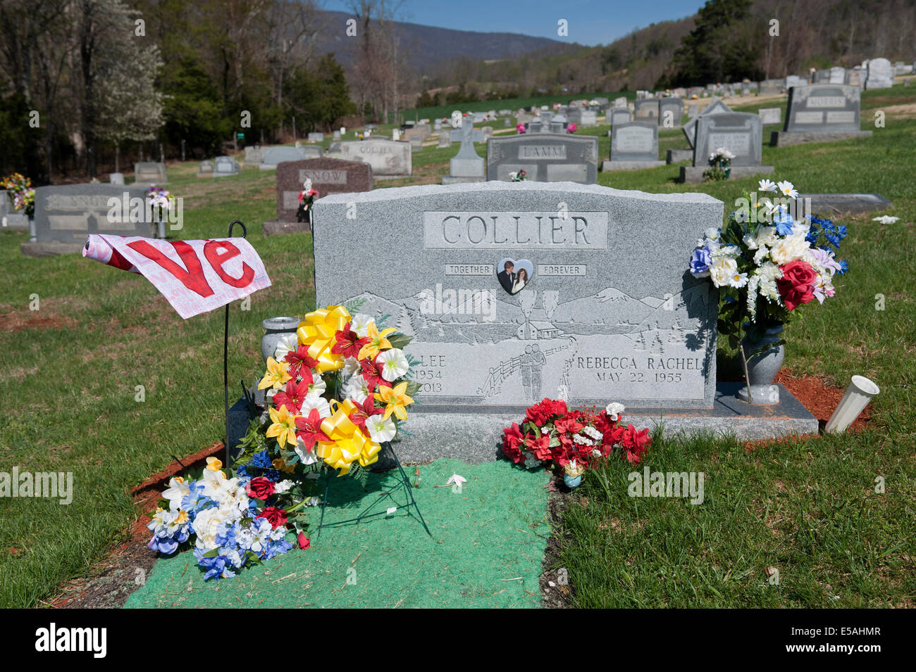 Grabstein mit Plastikblumen dekoriert. Stockfoto