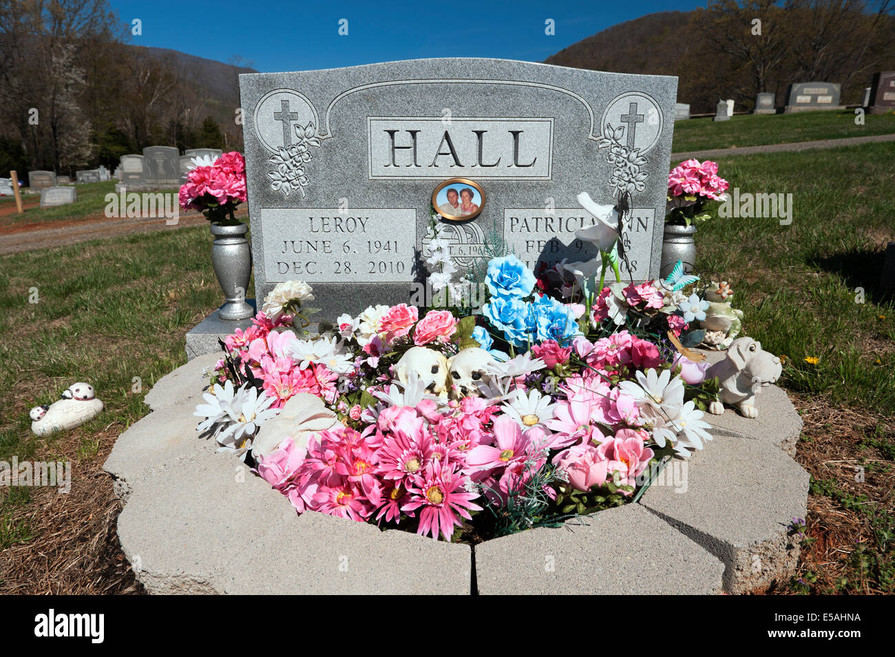Mann und Frau Grabstein mit Plastikblumen dekoriert. Stockfoto