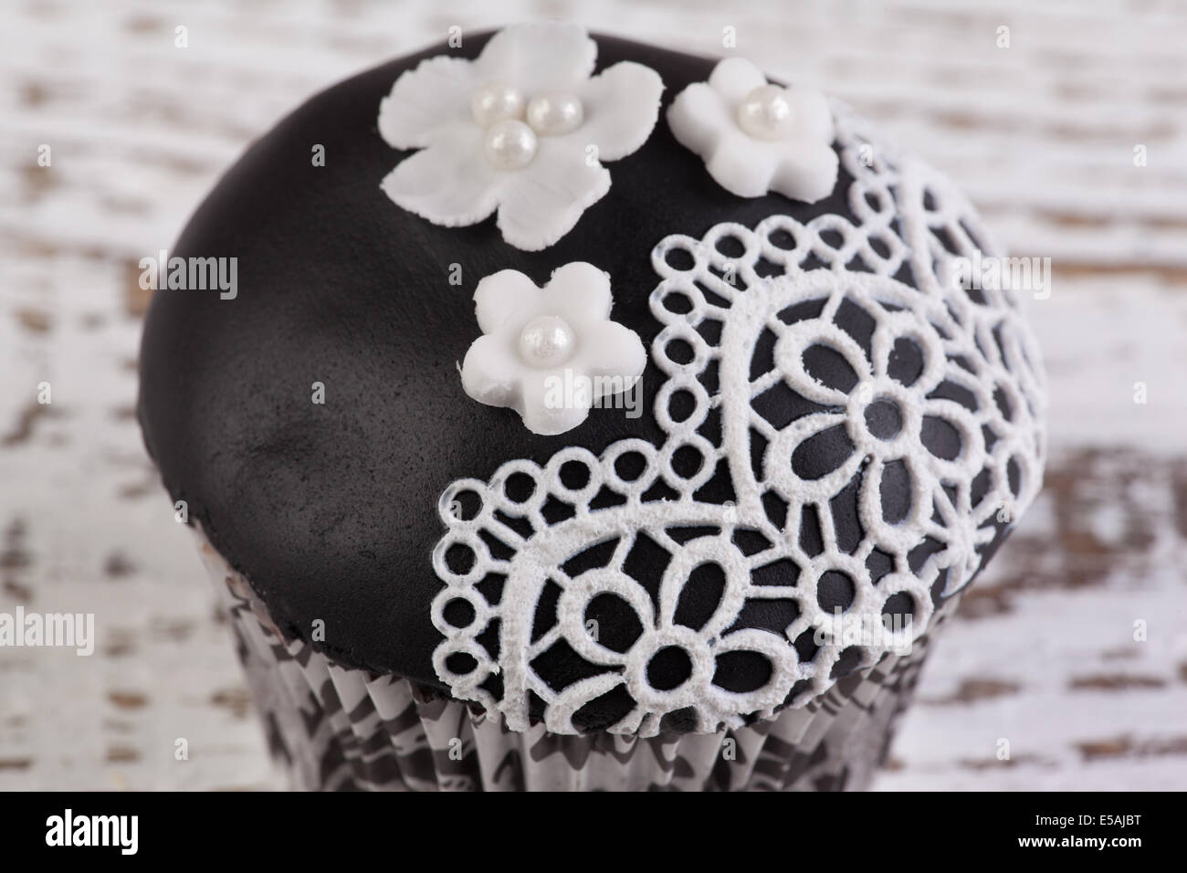 schwarzen Cupcake mit weißer Spitze essbar Stockfoto