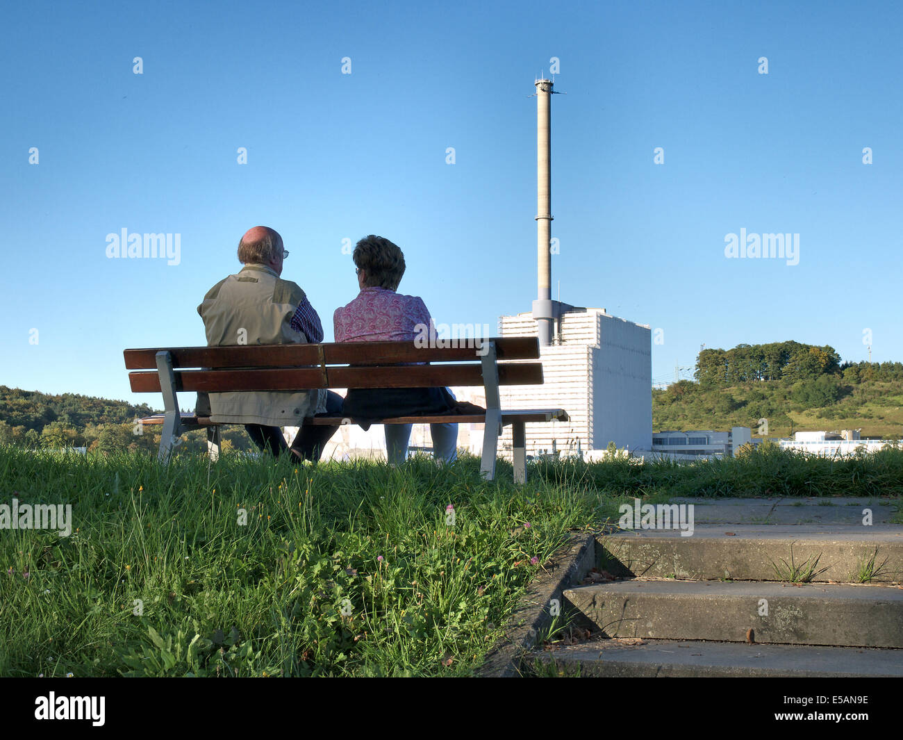 Älteres Ehepaar ruht auf einer Bank auf dem Elbe-Deich in der Nähe von Tespe beobachten die Nuclear Power Plant Krümmel, Geesthacht, Schleswig-H Stockfoto