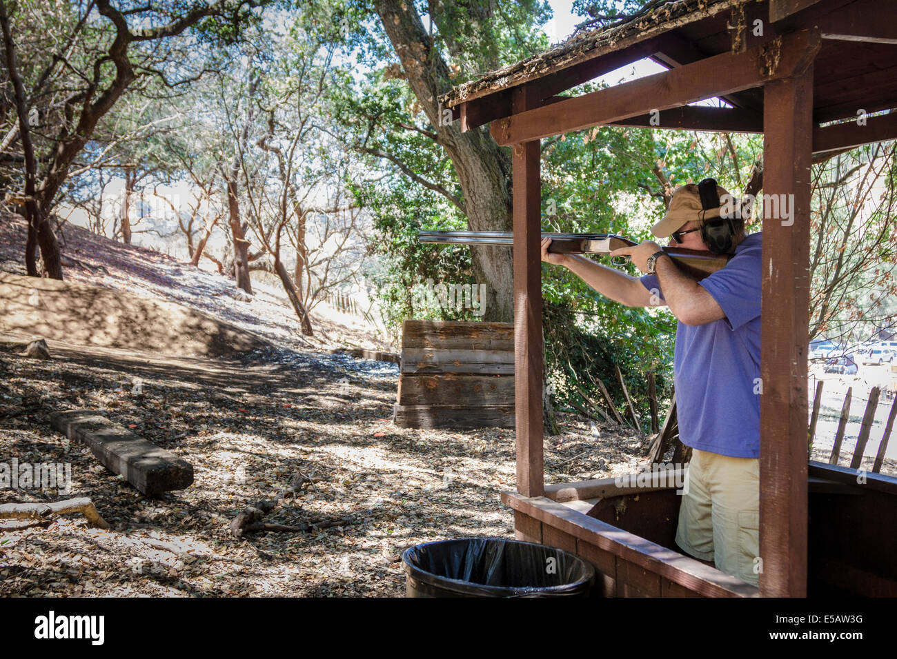 Mann schießen sportliche Tone mit seiner Schrotflinte auf einem Kurs in den Wäldern in Kalifornien Stockfoto