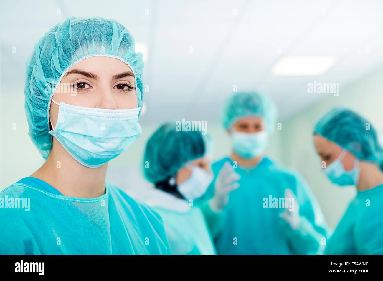 Junge weibliche Chirurg mit Ärzteteam auf der Rückseite vor der Operation Debica, Polen Stockfoto