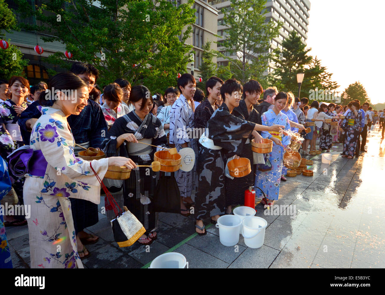 25. Juli 2014, Tokyo, Japan - ändern Arbeiter aus den Büros nahe Tokyo Station ihre Kleider Sommer Roben wie sie im Wasser, Japans langjährige Gewohnheit zu Temperaturen halten, während einer Veranstaltung auf dem Hauptboulevard führt vom Hauptbahnhof der Hauptstadt zum Kaiserpalast auf Freitag, 25. Juli 2014 teilnehmen. (Foto von Natsuki Sakai/AFLO) AYF - mis- Stockfoto