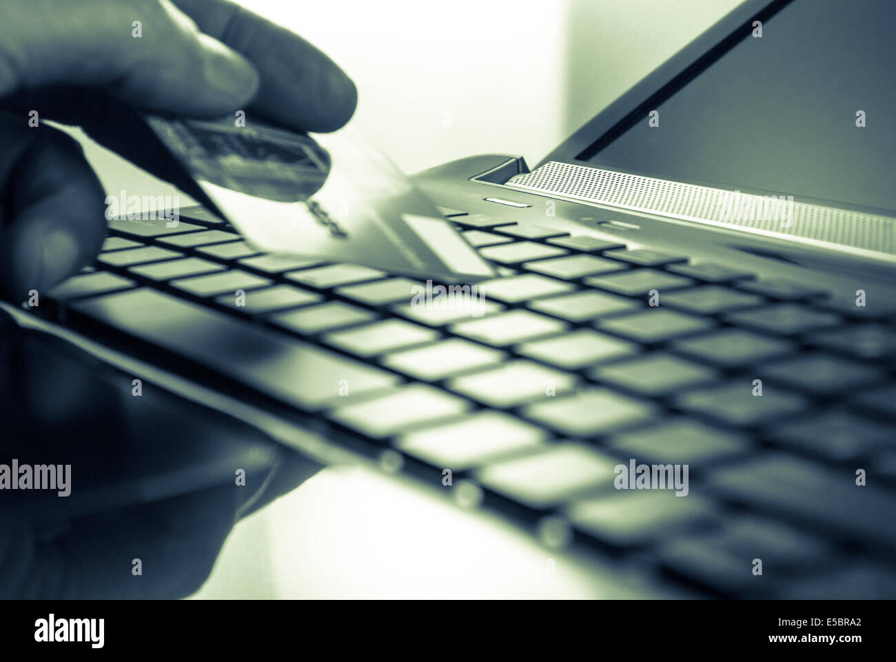 Mans Hand mit Kreditkarte und offene schwarze Laptop-Tastatur Stockfoto
